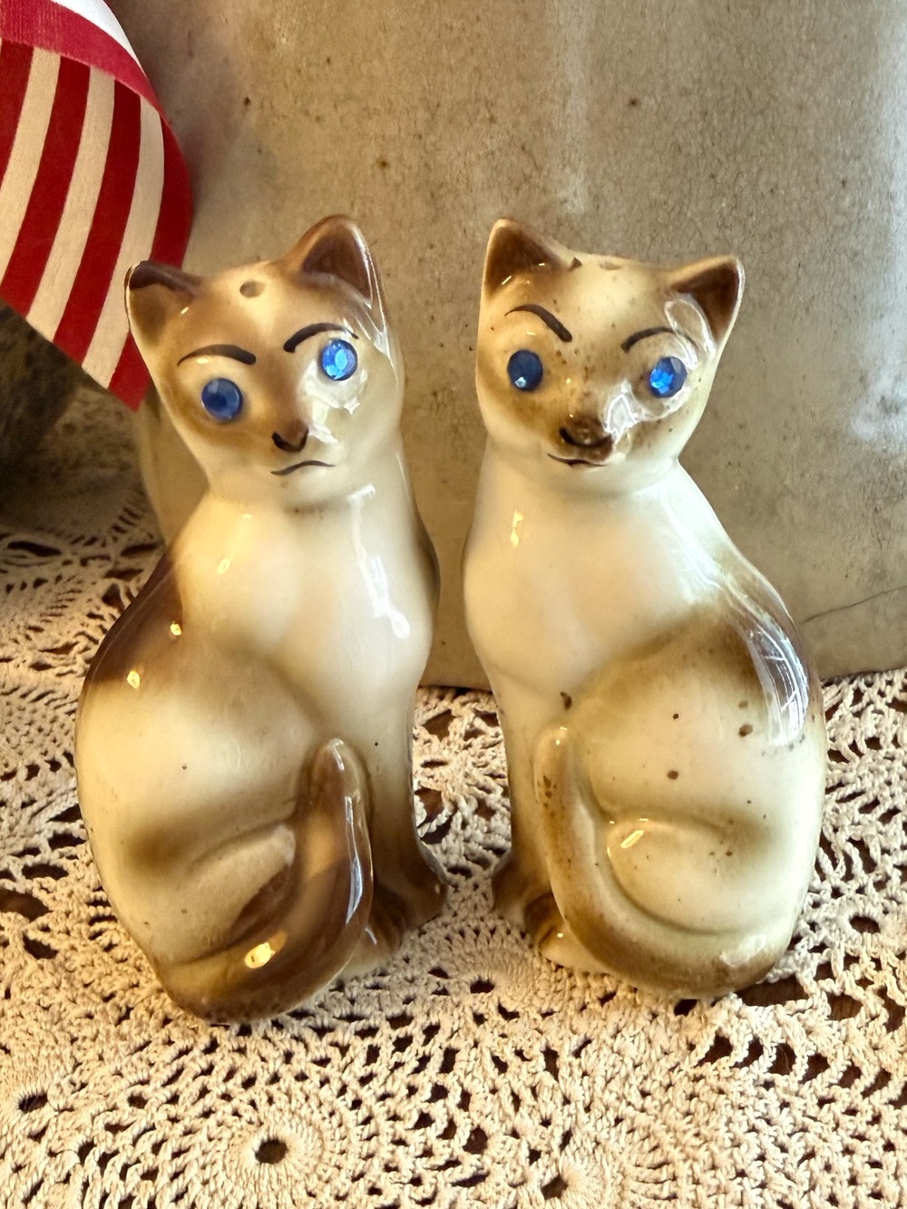 Vintage Siamese cat salt and pepper shakers with blue rhinestone eyes.